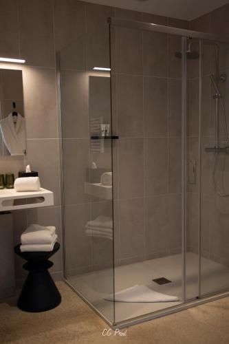 une douche avec une porte vitrée dans une salle de bain dans l'établissement La Maison du Gindreau, à Saint-Médard