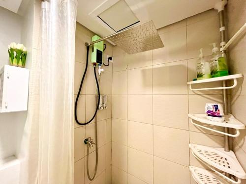 Casa Diana Pine Suites Tagaytay, Free Wi-Fi في تاجيتاي: حمام مع دش مع ستارة دش