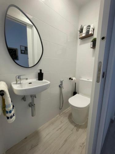 a bathroom with a sink and a toilet and a mirror at Apartamentos Isla Canela y Punta del Moral in Isla Canela