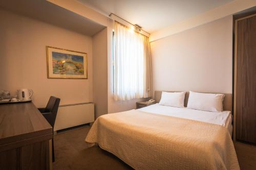 a hotel room with a bed and a window at Apollonia Hotel Gevgelija in Gevgelija