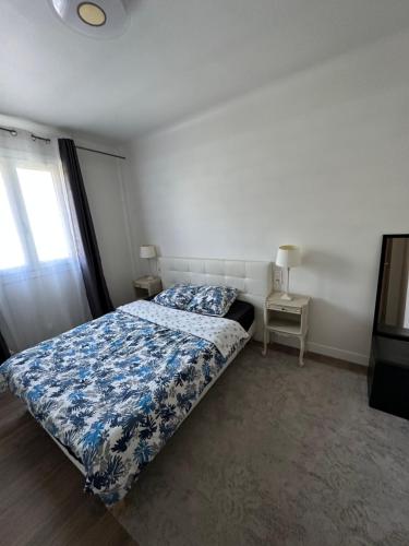 une chambre avec un lit avec une couette bleue et blanche dans l'établissement DYLAN Apartment, near Paris, à Montreuil