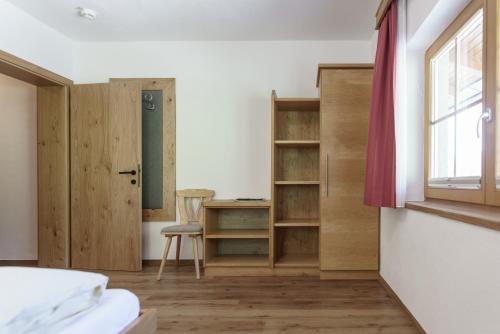 a room with a bed and a desk and a window at Pension Bergbauernhof Irxner in Schladming
