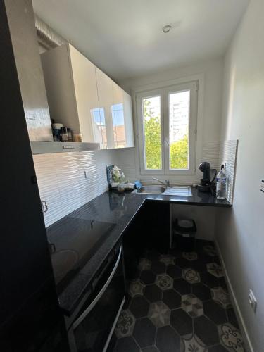 une petite cuisine avec un évier et une fenêtre dans l'établissement DYLAN Apartment, near Paris, à Montreuil