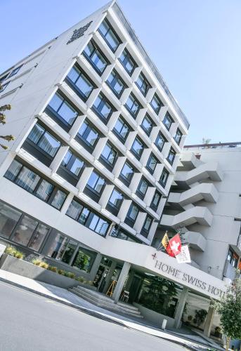 a building with a hotel on the side of it at Home Swiss Hotel in Geneva