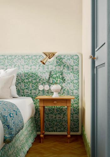 a bedroom with a bed and a table with a wall at Hôtel Amista Marseille - ancien Hôtel Saint Louis - Vieux Port in Marseille