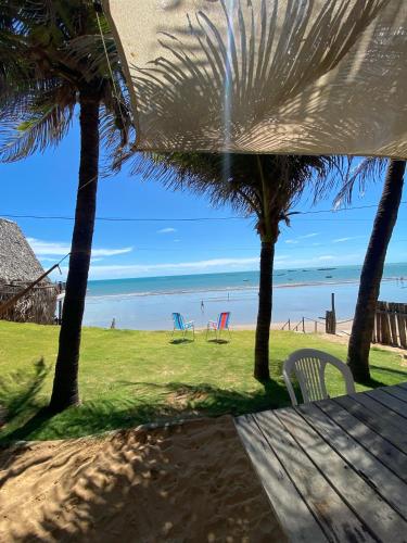 a view of a beach with chairs and palm trees at Casa da Peroba Sol - Pé na Areia - Praia da Peroba - Icapuí in Icapuí