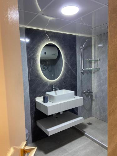 a bathroom with a sink and a shower with a mirror at Garden Residence in Dubai