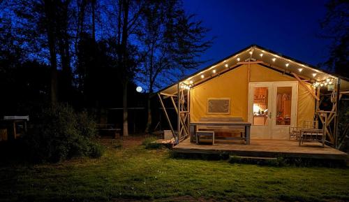 a large yellow tent with lights on it at night at Glampingtent Grou in Grou