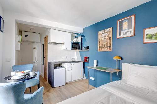 Cette petite chambre comprend un lit et un mur bleu. dans l'établissement Le Reve Parisien a Montorgueil, à Paris
