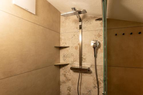 a shower with a glass door in a bathroom at Pension Bergbauernhof Irxner in Schladming