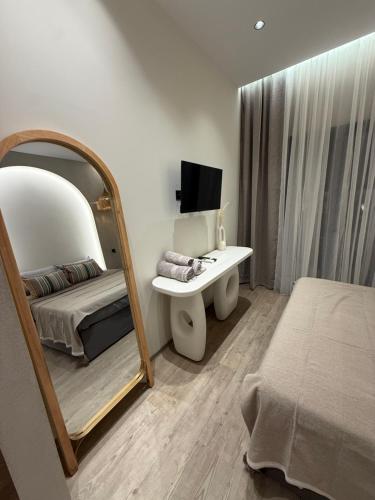 a bedroom with a mirror and a bed and a sink at Erasmia Beachside Suites in Georgioupolis