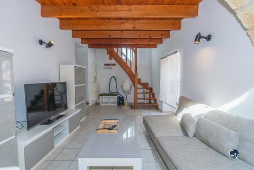 un salon avec un canapé et une télévision dans l'établissement Joli appartement avec Mezzanine, à Roquemaure