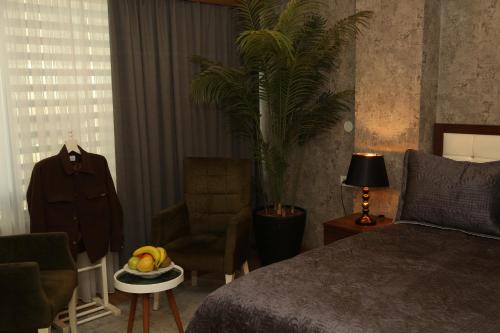 a bedroom with a bed and a table with a bowl of fruit at Cebeci Grand Hotel in Trabzon