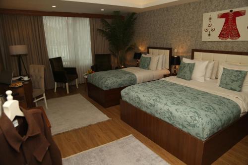 a hotel room with two beds and a table and chairs at Cebeci Grand Hotel in Trabzon
