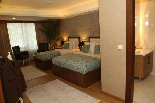 a hotel room with two beds and a bathroom at Cebeci Grand Hotel in Trabzon