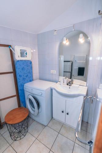 une salle de bain avec un lavabo et une machine à laver dans l'établissement Joli appartement avec Mezzanine, à Roquemaure