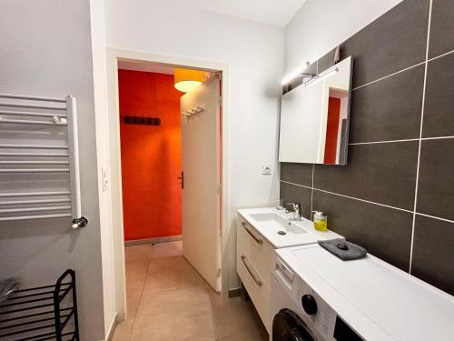une salle de bain avec un lavabo et une machine à laver dans l'établissement Casamea - Terrasse, Proche Hôpital, WiFi, Clim, à Ajaccio