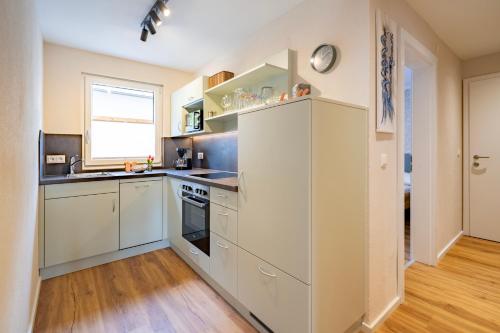 a kitchen with white cabinets and a window at Haus Nowak Ferienwohnungen in Millstatt