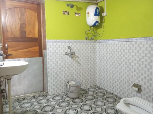 a green bathroom with a sink and a toilet at R N HomeStay in Dirang Dzong