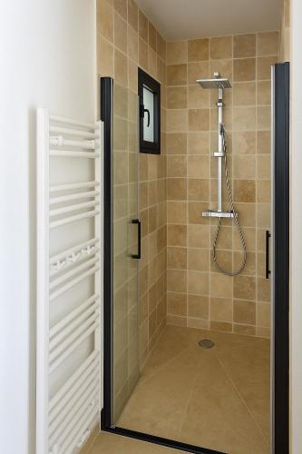 une douche avec une porte vitrée dans une salle de bain dans l'établissement Votre havre de paix à Patrimonio, à Patrimonio