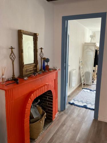 un salon avec une cheminée rouge et un miroir dans l'établissement Serenita - WiFi, Vue Mer, Central, à Bonifacio