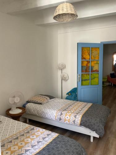 - une chambre avec 2 lits et une porte bleue dans l'établissement Serenita - WiFi, Vue Mer, Central, à Bonifacio