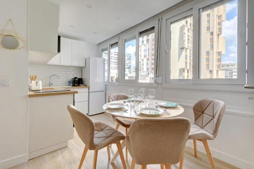 une cuisine avec une table et des chaises dans une pièce dans l'établissement Sublim and new apartment in Buttes-Chaumont, à Paris