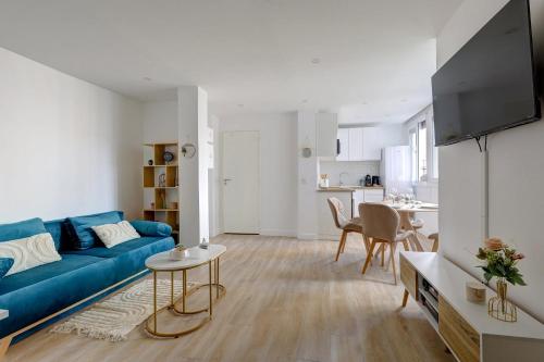 un salon avec un canapé bleu et une cuisine dans l'établissement Sublim and new apartment in Buttes-Chaumont, à Paris