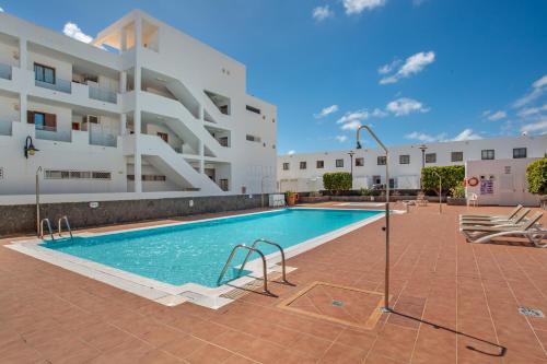 a swimming pool in front of a building at Casa Rosa in Costa Teguise