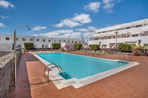 a large swimming pool in front of a building at Casa Rosa in Costa Teguise