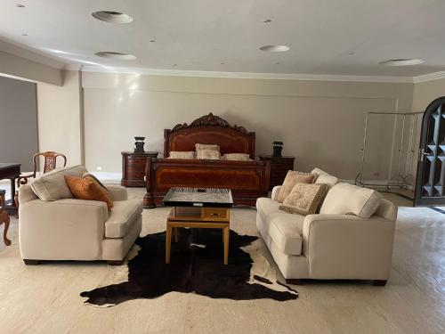 a living room with two couches and a piano at Condo in a Private Resort setting King Maryout Alamriyah Governorate Egypt Comes with an outdoor private infinity swimming pool with a large garden Borg Alarb International Airport is 15 minutes- Families Only in Alexandria