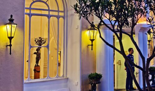a man standing in front of a building with a window at Hotel Quisisana in Capri