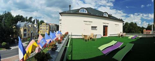 a building with a lawn with flags on it at Esplanade, dependance hotelu Monti Spa in Františkovy Lázně