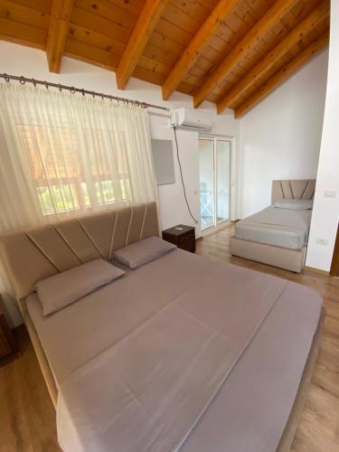 una camera da letto con un grande letto e un divano di Benjys Vila a Shëngjin