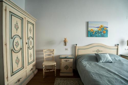 a bedroom with a bed and a chair and a table at Pensiunea Cocosel in Căstău