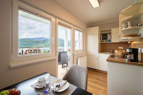 a kitchen with a table and a large window at Haus Nowak Ferienwohnungen in Millstatt