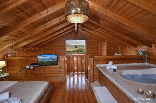 a bathroom with a large tub in a wooden cabin at בקתה בשמורה in Shomera
