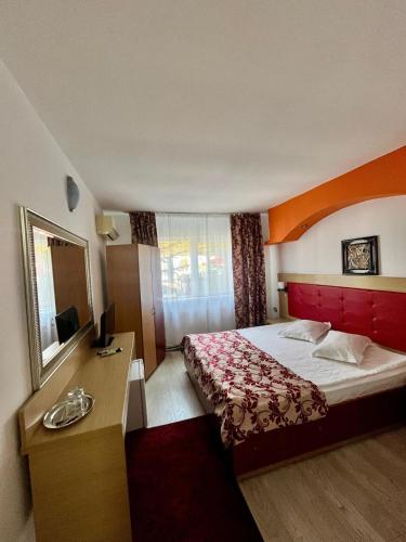 a hotel room with a bed with a red headboard at Casa Coral Sulina in Sulina