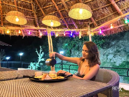 uma mulher sentada à mesa com um prato de comida em Anandvan Jungle Resort by Dev Group of Hotels em Rishikesh
