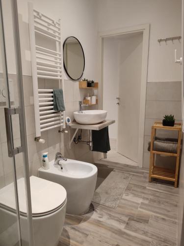 a bathroom with two sinks and a toilet and a mirror at Casa André Imola in Imola