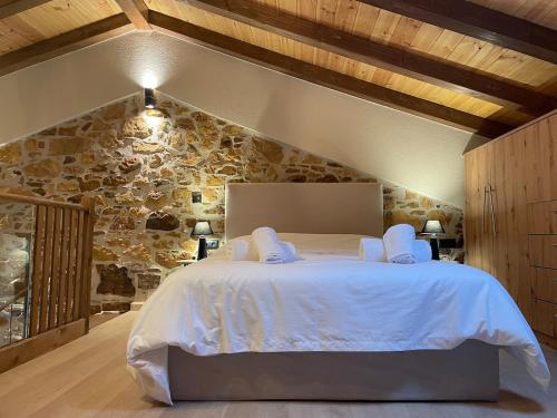 a bedroom with a large bed in a stone wall at Downtown ViAlla in Chios