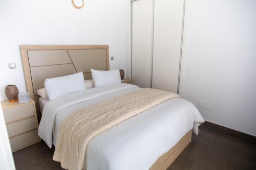 a bedroom with a large white bed with white sheets at Maya Bay Suites in Alicante