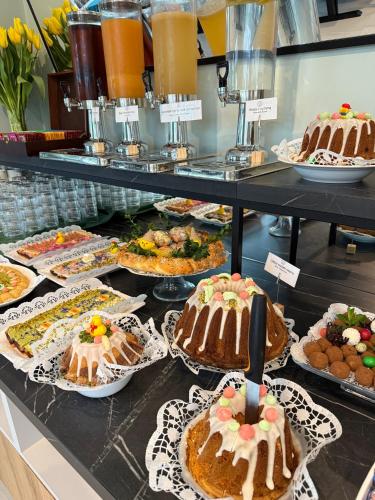 a display case filled with cakes and other desserts at KASHUBIAN Resort in Władysławowo