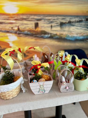 a table with baskets of easter eggs and plants at KASHUBIAN Resort in Władysławowo