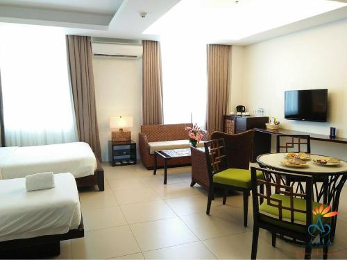 a hotel room with a bed and a table and chairs at Azia Suites and Residences in Cebu City