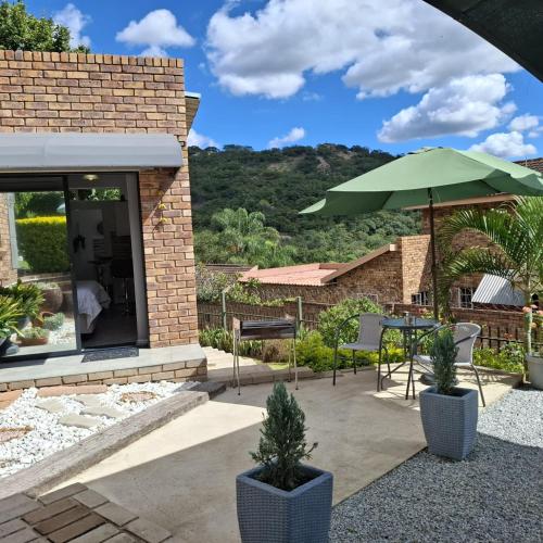 a patio with a table and an umbrella at Sleep Haven Self-Catering Accommodation - Nelspruit in Nelspruit