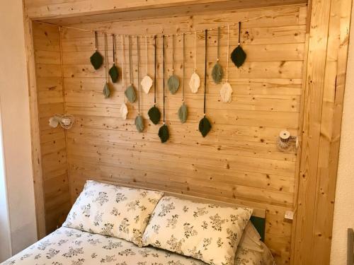 - une chambre avec un mur en bois et un lit dans l'établissement T3 proche du Viaduc de Millau, à Saint-Georges-de-Luzençon