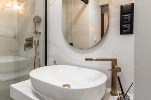 a bathroom with a white sink and a mirror at APARTAMENT przy stoku Białka Tatrzańska Spa & Resort in Białka Tatrzanska