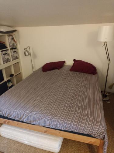 - un lit avec 2 oreillers rouges dans l'établissement Maison Pierrerue, à Pierrerue