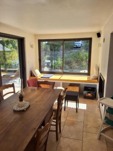 une salle à manger avec une table et une grande fenêtre dans l'établissement Maison Pierrerue, à Pierrerue